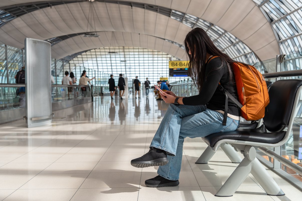 Woman waiting at airport checking flight info
