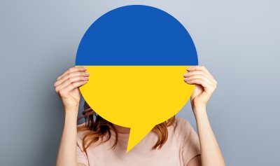 Woman holding speech balloon with colours of the Ukrainian flag
