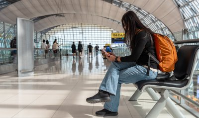 Woman waiting at airport checking flight info